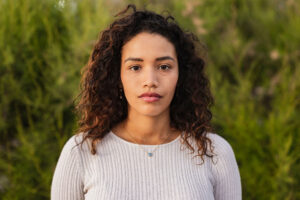 serious looking young woman reflecting on understanding the link between substance abuse and mental health.